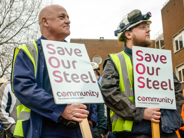 Workers stand with signs at Tata steel works Getty