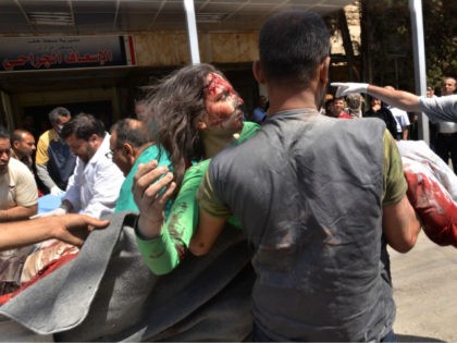 SYRIA, ALEPPO : EDITORS NOTE: Graphic content / A Syrian civil defence member carries a wounded woman into a hospital in the government-controlled side of the northern city of Aleppo following fighting between regime forces and rebels on April 28, 2016. The Syrian army was preparing an offensive to retake …