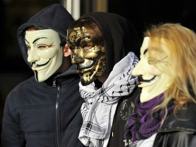 People wearing Guy Fawkes masks demonstrate prior to the trial of three 'Anonymous&#0