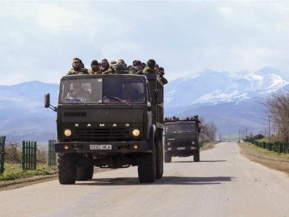 Ethnic Armenian fighters stand in backs of Kamaz military trucks on their way to a frontli
