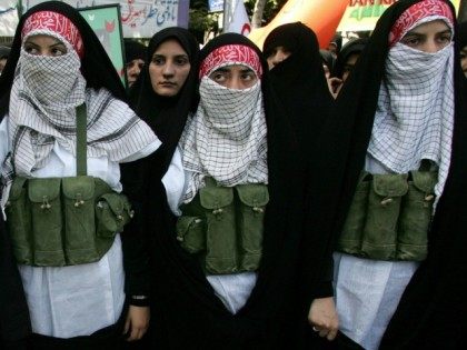 Tehran, IRAN: Iranian women dressed as suicide bombers stand next to a portrait of 19-year-old Palestinian female suicide bomber Hiba Azem Daraghma during a demonstration in downtown Tehran, 31 July 2006.