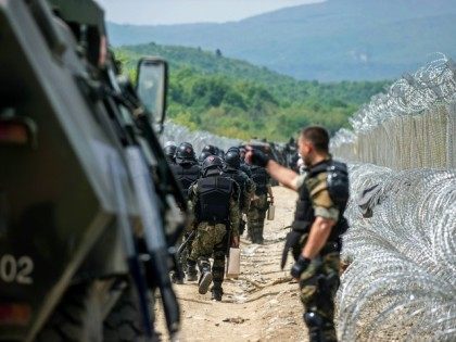 Macedonian police deploy their forces near the razor wire fence at Greek-Macedonian border