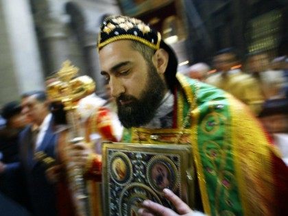 A Coptic priest advances 04 April 2004 inside the Holy Sepulchre Church in Jerusalem on Palm Sunday as hundreds of followers of the different branches of Christianity began Easter celebrations by parading through Jerusalem's Old City before praying at the Church of the Holy Sepulchre, believed to be the final …