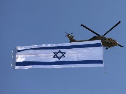 An Israeli Blackhawk helicopter performs with the Israeli flag during an air show as part of a graduation ceremony of Israeli pilots at the Hatzerim air force base in the southern Negev desert, near the city of Beersheva, on June 25, 2015.