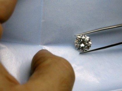 Israeli diamond dealer Alon Haimov inspects a 5-carat brilliant cut white diamond, worth a