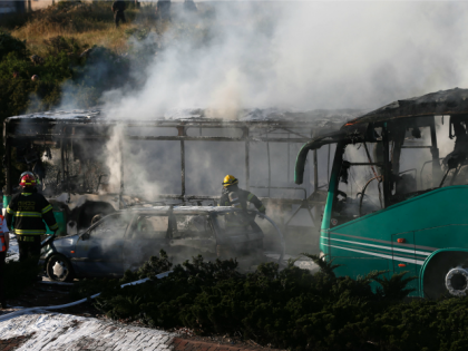Firemen extinguish a burning bus following an attack in Jerusalem on April 18, 2016. Polic
