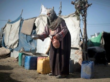 A Palestinian Bedouin woman washes a bowl on October 22, 2013 at an encampment where she lives with her family in tents amid harsh living conditions with no electricity in southern Gaza City.