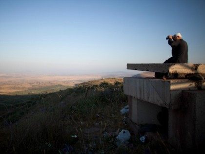 A Druze man looks at the nearby Syrian village of Jebata al-Khashabn from an Israeli army post near the village of Buqaata at the Israeli side of the border on July 24, 2012 in the Golan Heights.