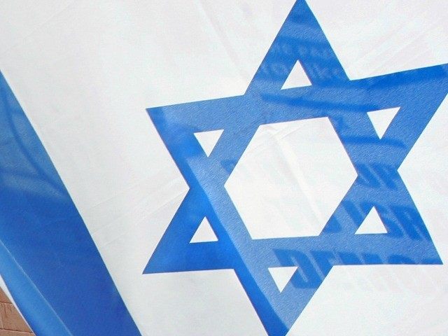 An activist waves an Israeli flag outside Israel's embassy in Moscow to voice support