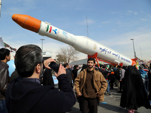 Iranians take pictures of the Simorgh (Phoenix) satellite rocket during celebrations in Te