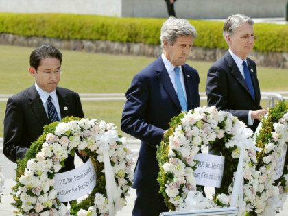 From left, Japan's Foreign Minister Fumio Kishida, U.S. Secretary of State John Kerry and Britain's Foreign Minister Philip Hammond carry wreath to offer at the cenotaph at Hiroshima Peace Memorial Park in Hiroshima, western Japan Monday, April 11, 2016. (Kyodo News via AP) JAPAN OUT, MANDATORY CREDIT