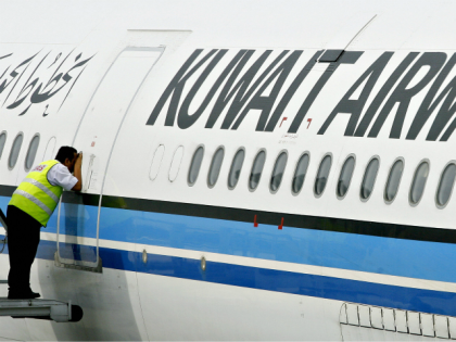 A ground crewmember takes a peek inside the cabin of a Kuwait Airways Airbus A340 at the K