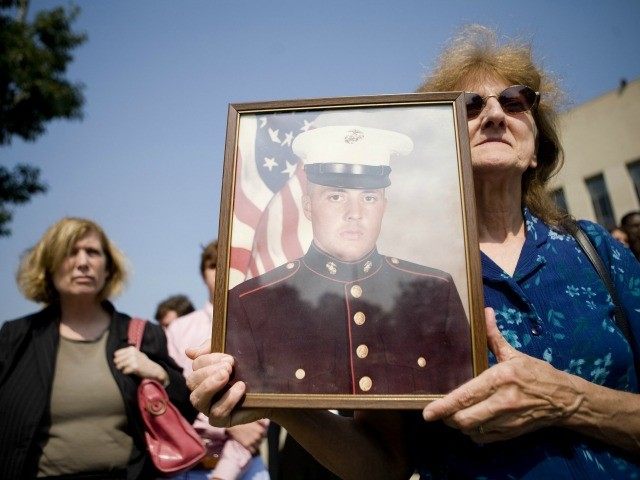 Edwin Marian Johnston hold up a photo of her son US Marine CPL Edward Johnston who died in