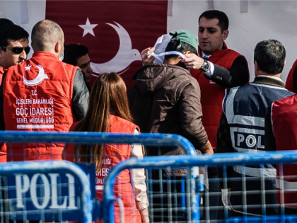A Turkish officer registers a deported migrant from Greece after the arrival of a small Turkish ferry carrying migrants who are deported to Turkey, on April 4, 2016 at the port of Dikili district in Izmir.