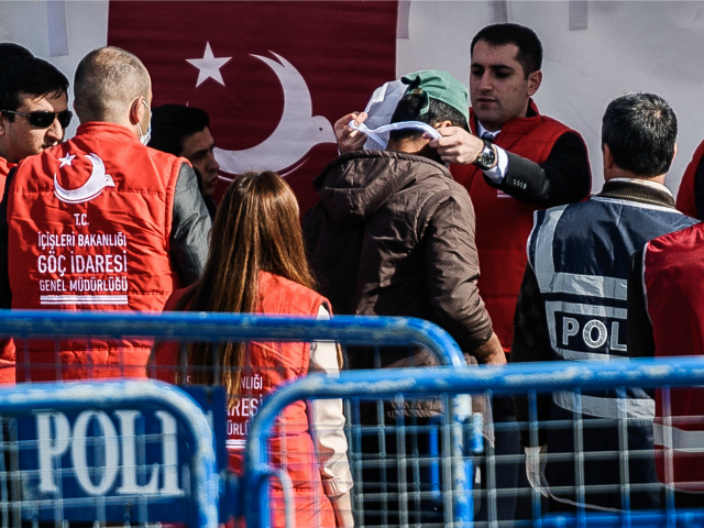 A Turkish officer registers a deported migrant from Greece after the arrival of a small Tu