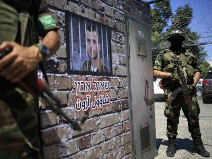 Members of the al-Qassam Brigades, Hamas' armed wing, stage a performance in which they stand guard outside a mural depicting a prison cell imitating where Israeli soldier Oron Shaul would have been held, during a presentation on September 2, 2015 at a main square in the centre of Gaza City.