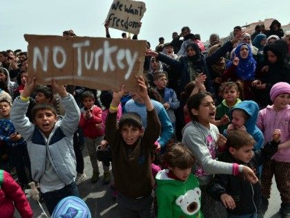 Refugees and migrants including children who left the Chios registration camp, shout sloga