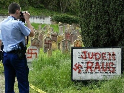 A French gendarme films, an anti-Semitic inscription written in German 'Jews Out' at a Jewish cemetery 30 April 2004 in Herrlisheim, in eastern France, where 127 graves have been desecrated.