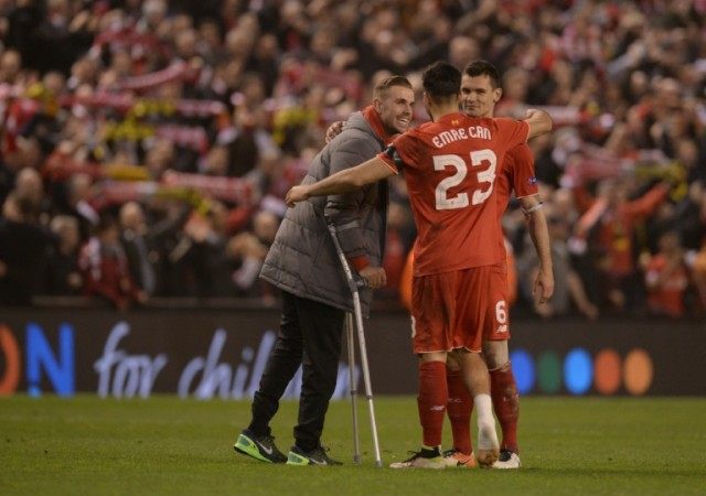 Liverpool midfielder Emre Can (C) limps towards teammate Dejan Lovren (R) and Jordan Hende