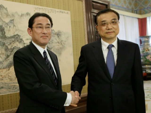 Japanese Foreign Minister Fumio Kishida (L) shakes hands with China's Premier Li Keqiang d