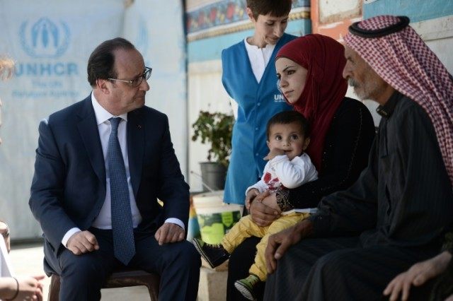 French President Francois Hollande (L) meets with a Syrian family at Dalhamiyeh refugee ca