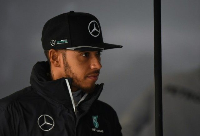 World champion Lewis Hamilton stands in the pits during the third practice session at the