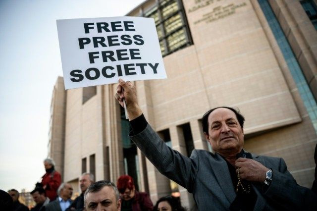 A demonstrator holds a placard reading "Free Press Free Society", outside the Istanbul cou