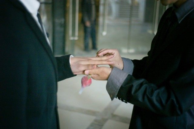 A gay couple exchange rings during their ceremonial 'wedding' in Wuhan, Hubei province