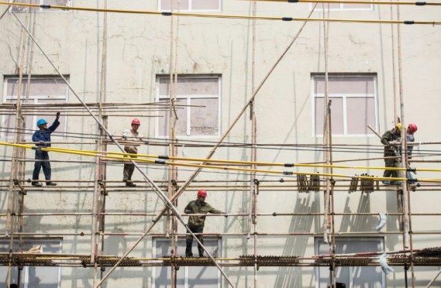 Workers set up bamboo scaffolding on a construction site in Shanghai on April 13, 2016