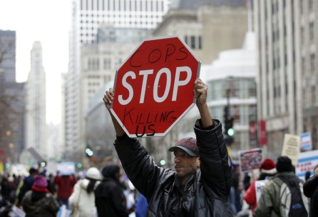 A demonstrator protesting the fatal police shooting of Laquan McDonald holds up a sign on