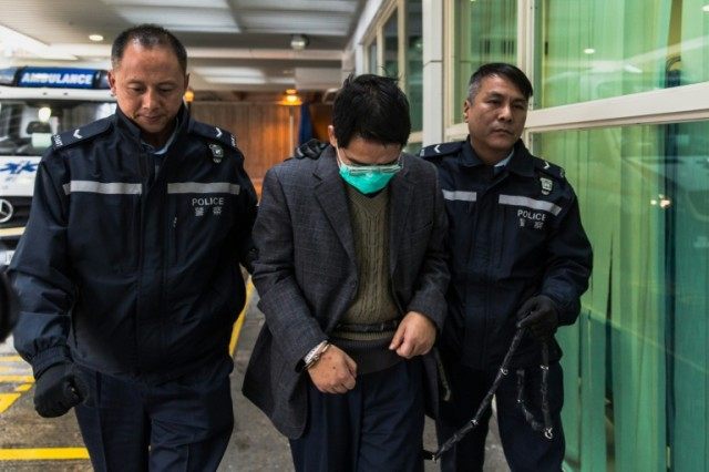 Shi Deyun, accused of murdering his two teenage nephews in the US, is escorted by police t