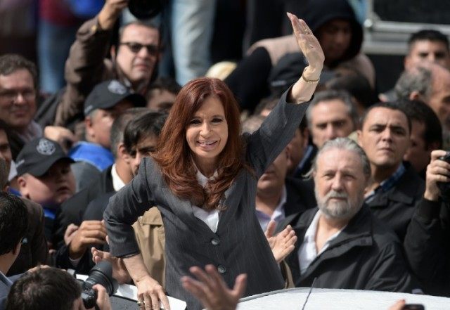 Argentina's former president Cristina Kirchner waves at supporters in front of the Comodor