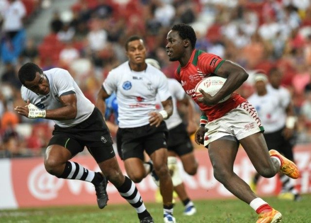 Kenya's Nelson Oyoo (R) runs with the ball against Fiji during the finalof the Singapore S