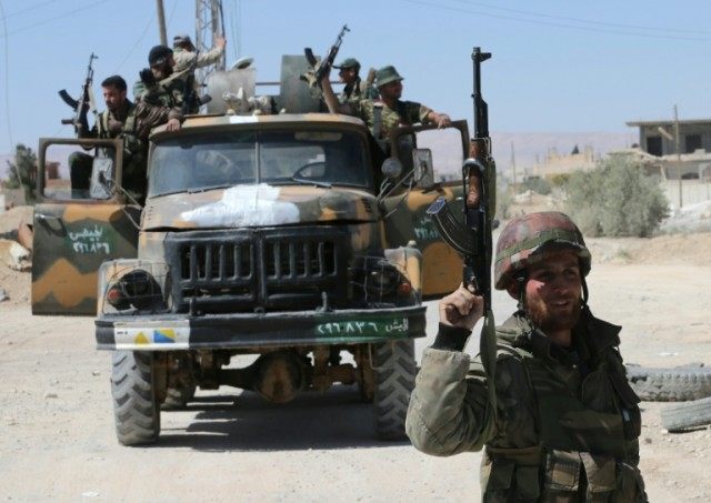 Syrian soldiers patrol the devastated town of al-Qaryatain on April 4, 2016 after regainin