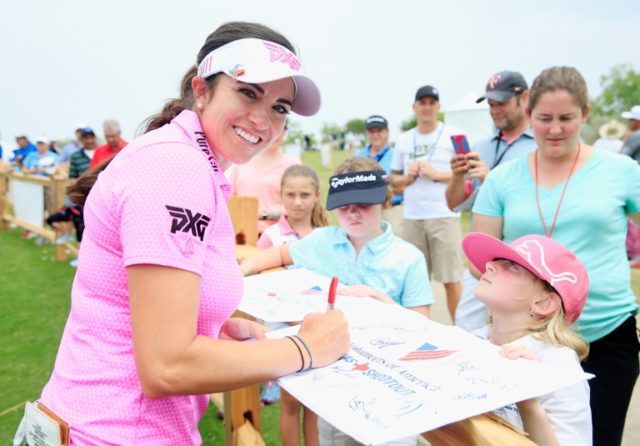 Gerina Piller signs an autograph for a fan after finishing with a six-under par 65 during