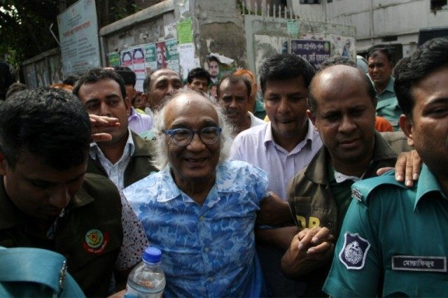 Bangladeshi security personnel escort magazine editor Shafik Rehman (C) outside a court in