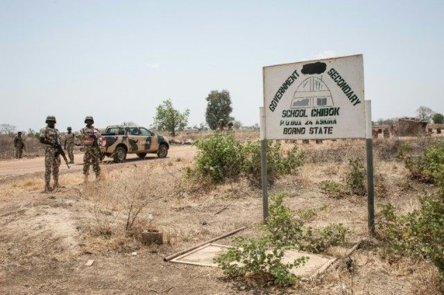 Soldiers from the Nigerian Army stand outside a school in Chibok on March 25, 2016