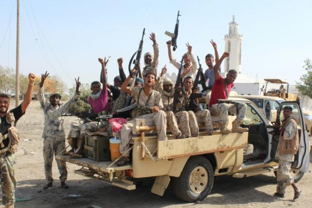 Forces loyal to the Saudi-backed Yemeni president cheer on a road in Abyan province as the