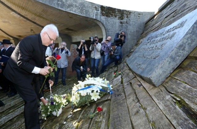 Former Croatian President Ivo Josipovic lays a wreath of flowers at a memorial in Jasenova