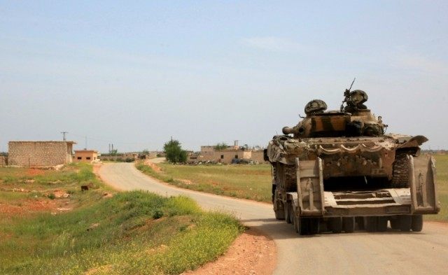 Syrian government forces patrol the town of Khan Tuman, south of Aleppo on April 11, 2016,