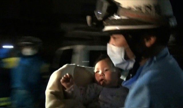 A rescue worker carries an eight-month-old baby girl after she was pulled from the rubble