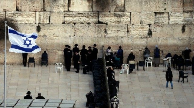 Ultra-Orthodox Jewsih men (L) and women (R) pray in two different sections at the Western