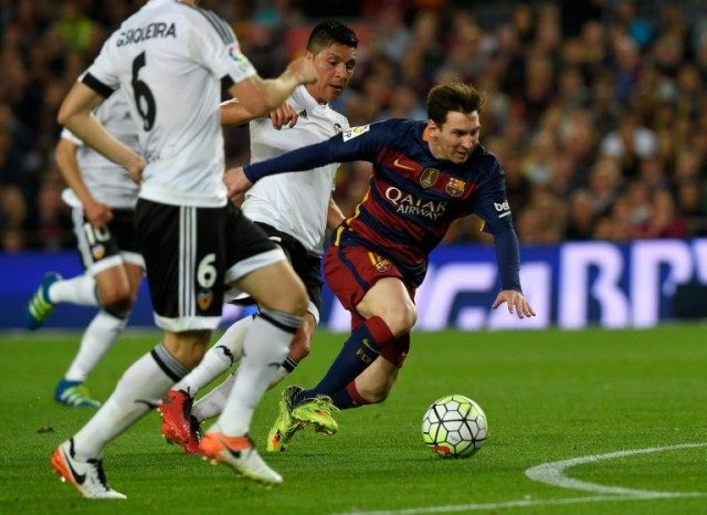 Barcelona's forward Lionel Messi (R) fights for the ball with Valencia's midfielder Enzo P