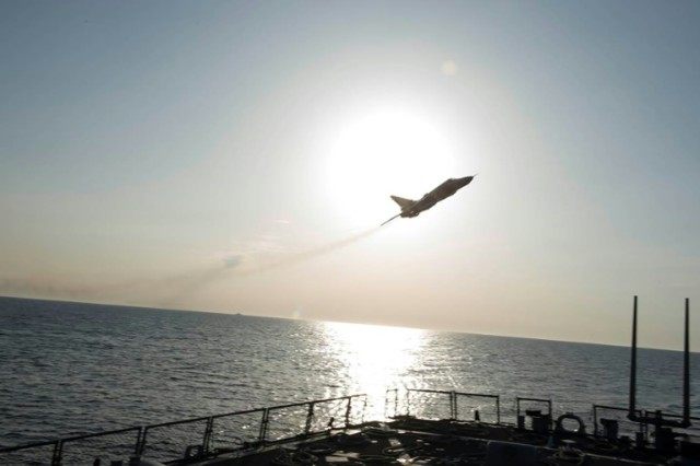 A Russian Sukhoi Su-24 attack aircraft makes a very-low altitude pass by the USS Donald Co