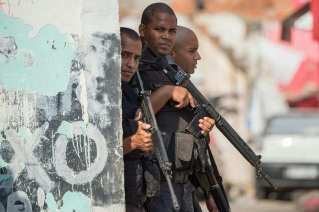 Armed police patrol the Chuveirinho favela in Rio's Alemao shantytown complex in March 201