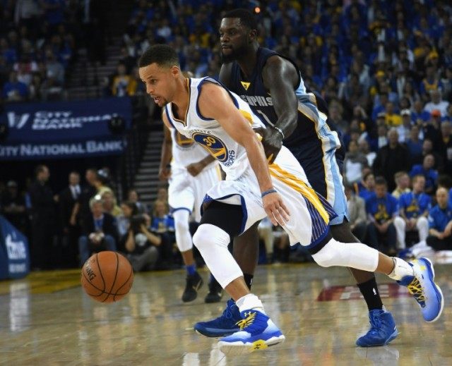 Stephen Curry (L) of the Golden State Warriors drives the ball past Lance Stephenson of th