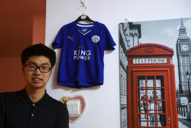 Leicester City fan Wang Song Aohan posing with a signed jersey in his apartment in Beijing