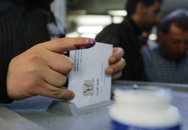 Syrians cast their votes for the parliamentary elections at a polling station in Damascus,
