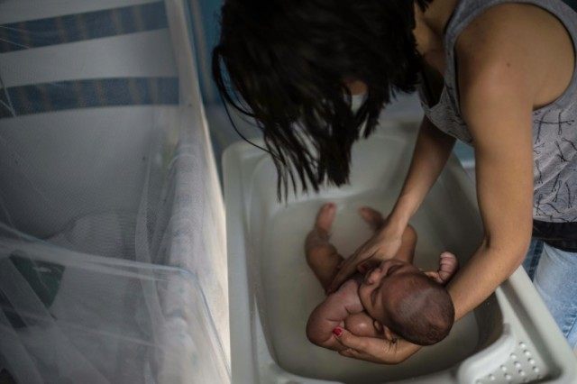 A woman bathes her son, suffering from microcephaly, in Salvador, Brazil on January 28, 20