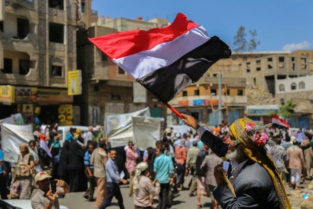 A Yemeni man waves the national flag during a protest in Taez against the ongoing conflict